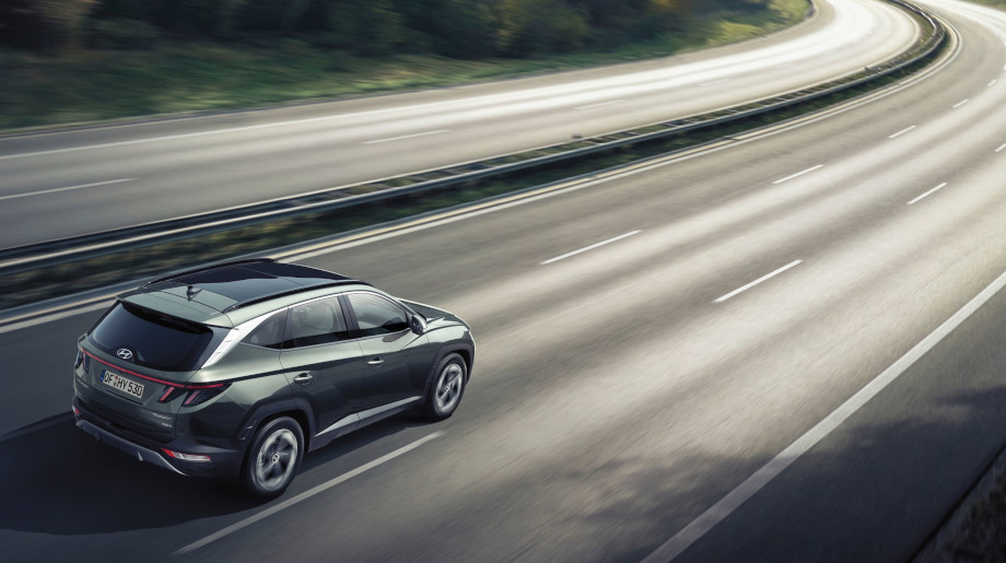 Zcela nové kompaktní SUV Hyundai TUCSON Hybrid jedoucí po dálnici.